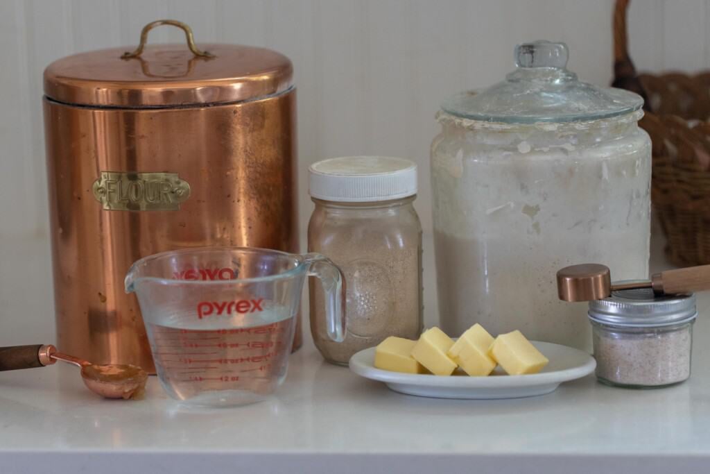 jars, canisters, measuring cups of ingredients on a white countertop