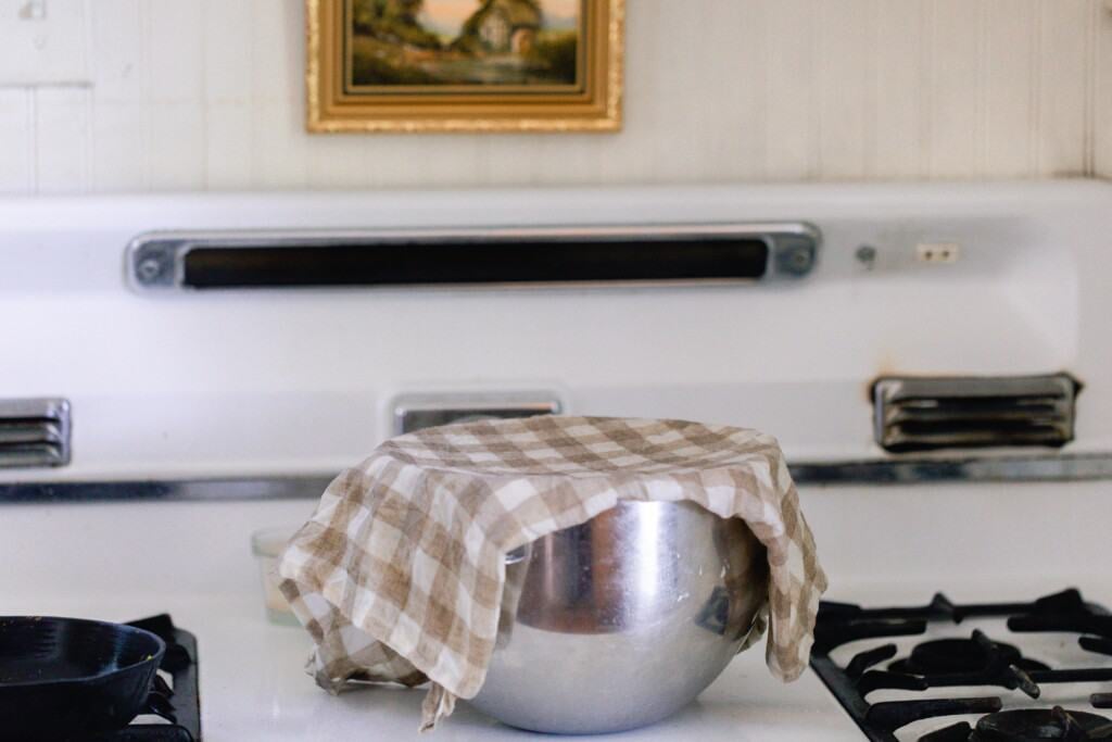 towel over a stainless bowl on a white vintage stove