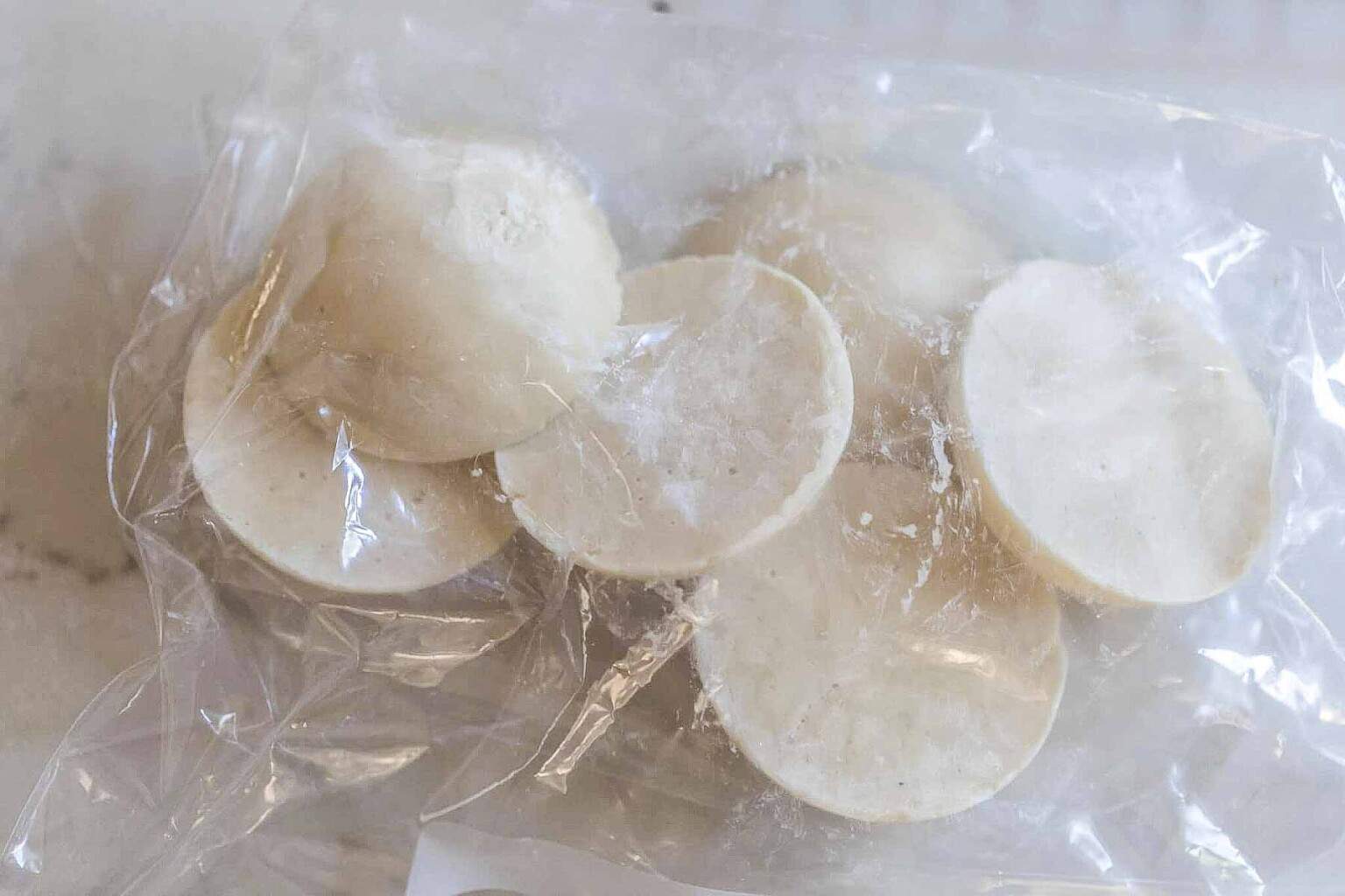 frozen sourdough starter in a plastic bag on a countertop.