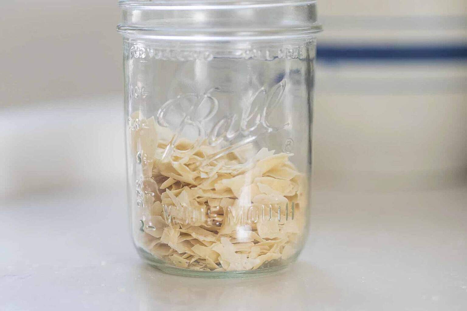 dehydrated sourdough starter in a glass mason jar on a white countertop.