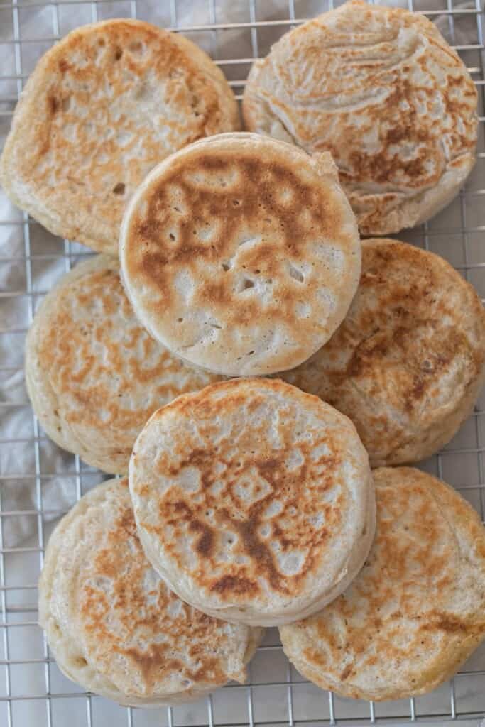 eight sourdough crumpets stacked in two layers on a cooling rack