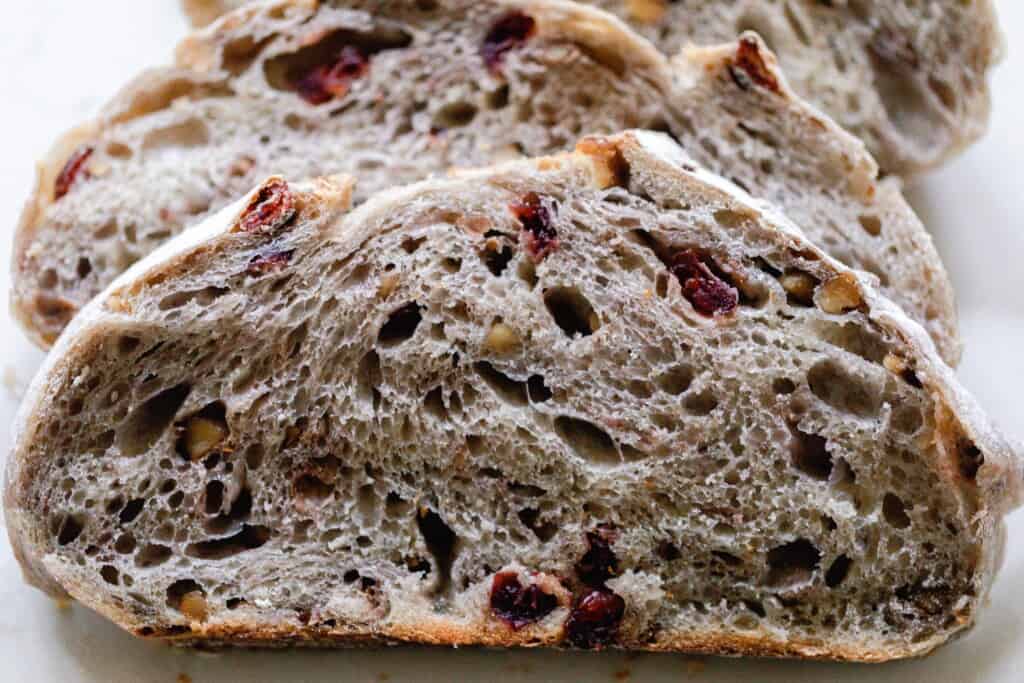 close up of a slice of cranberry walnut sourdough bread