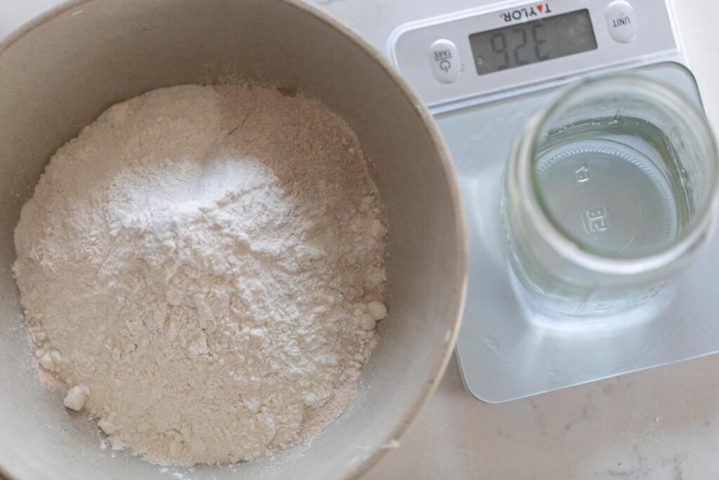 flours added ro a ironstone bowl with a jar of water to the right