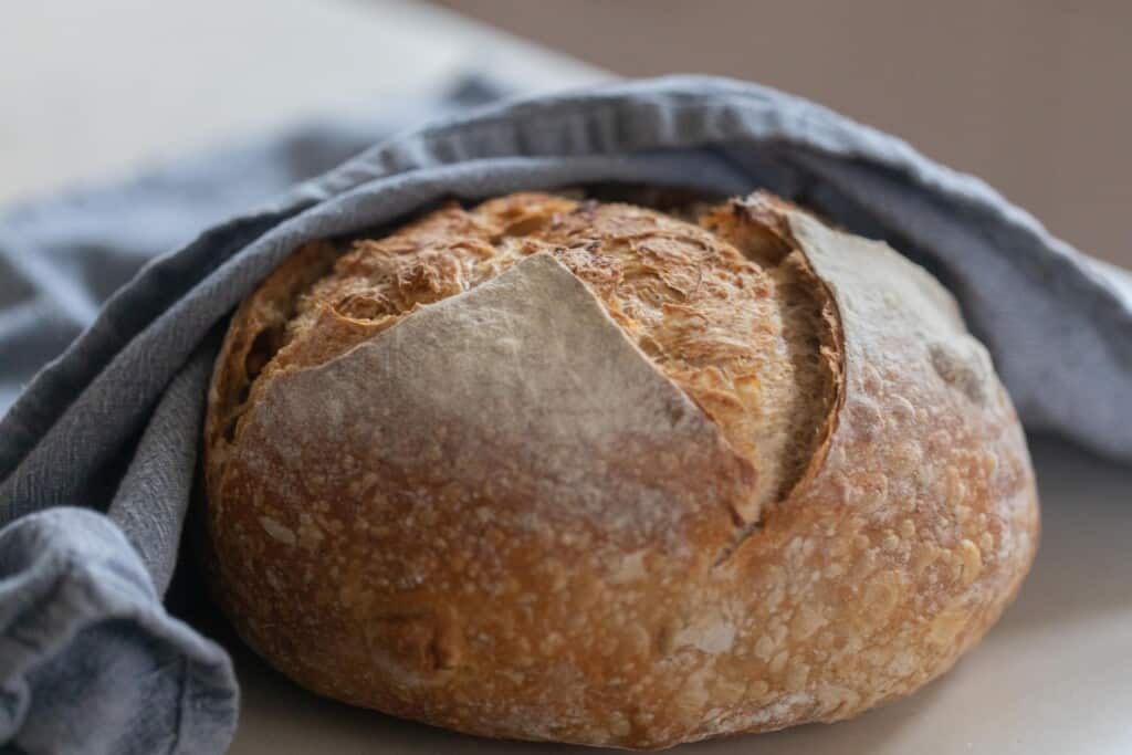 load of garlic sourdough bread wrapped in a blue towel