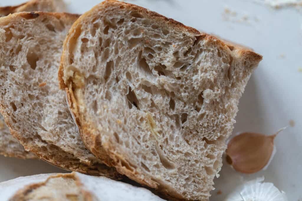 a slice of garlic sourdough bread on a white countertop