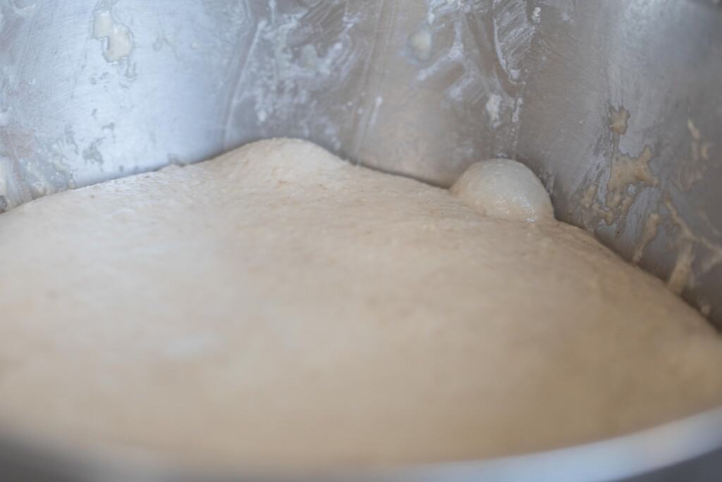 high hydration sourdough in a silver bowl with bubbles after bulk fermentation