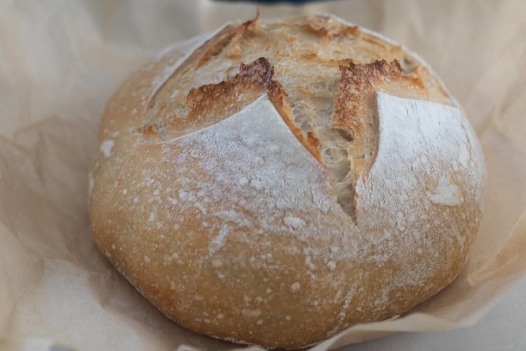 close up of a high hydration sourdough loaf on a piece of parchment paper