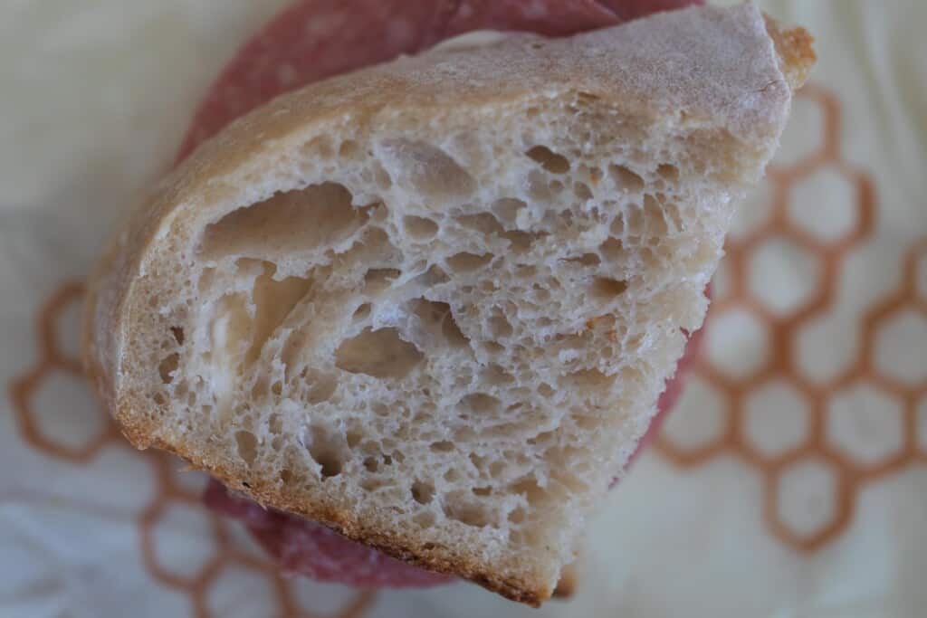 A slice of high hydration sourdough bread on top of a beeswax wrap