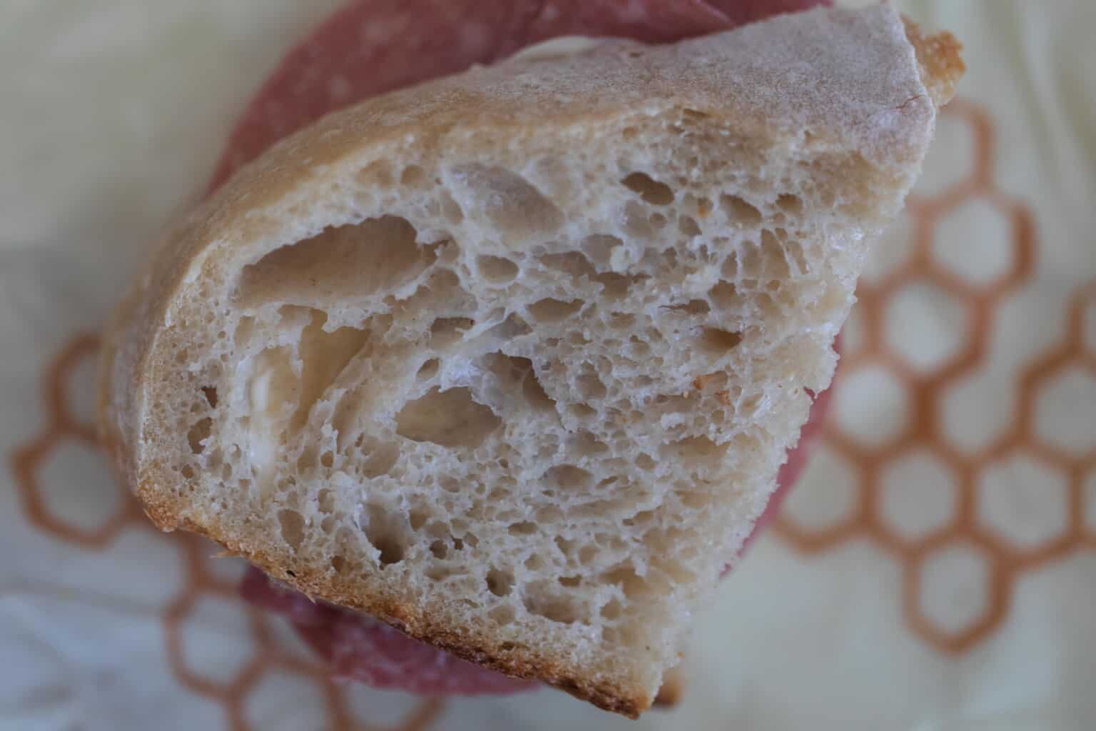 A slice of high hydration sourdough bread on top of a beeswax wrap