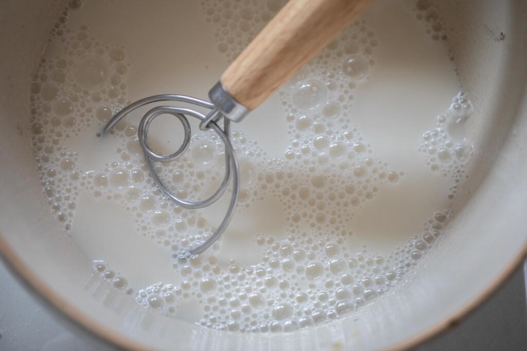 sourdough starter in large white bowl with dough whisk