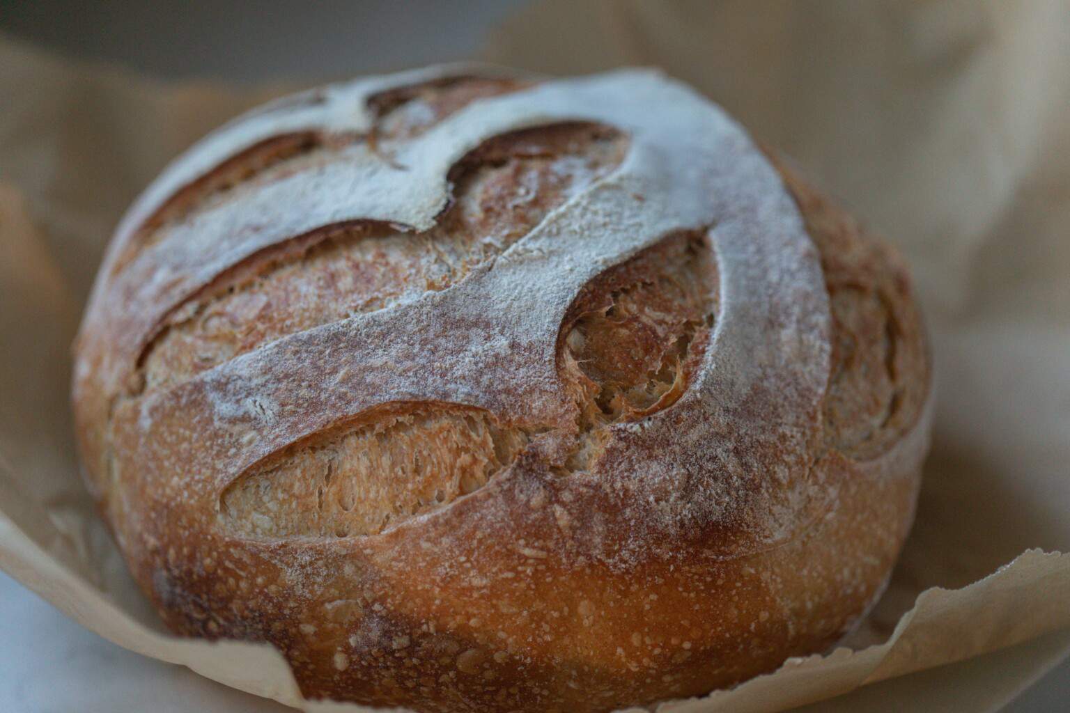 A loaf of honey sourdough bread in parchment paper