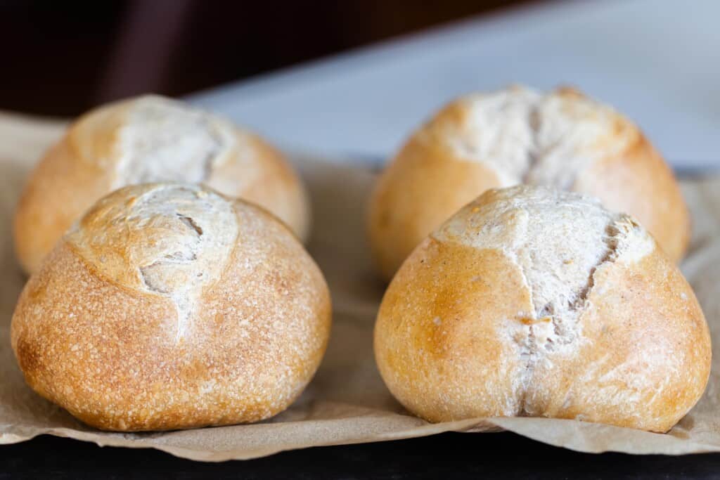 four mini sourdough loaves baked to golden brown