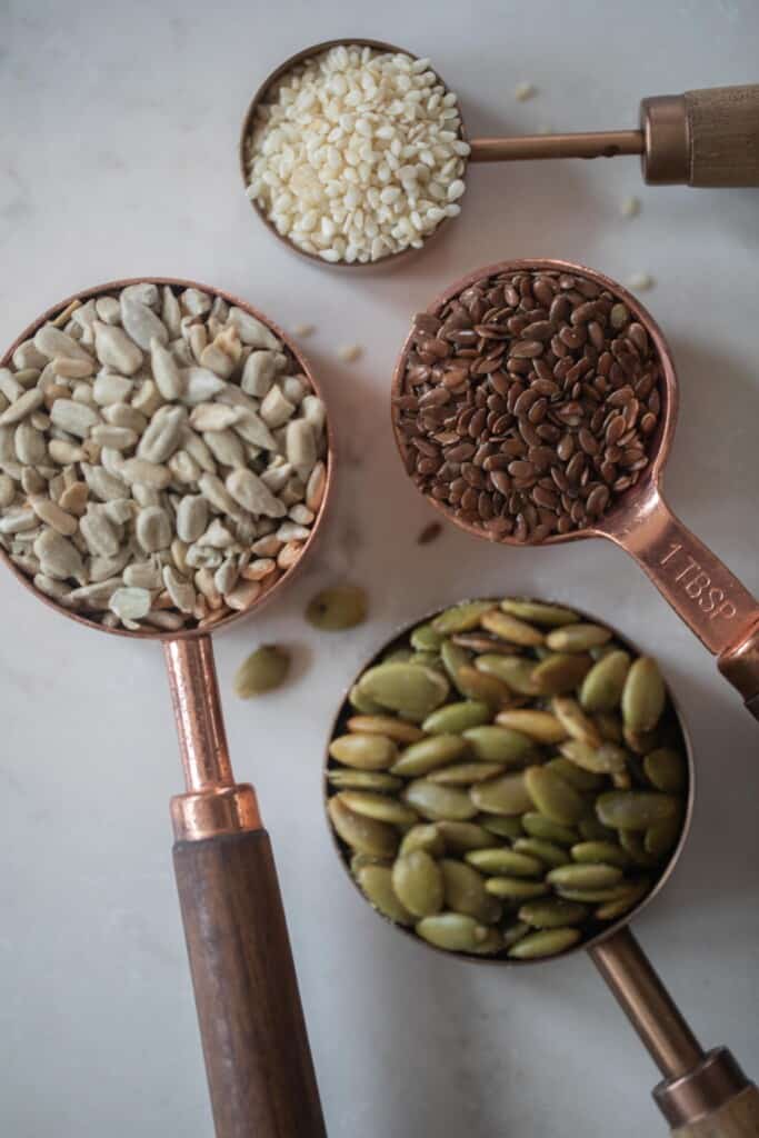 Measuring cups holding various seeds
