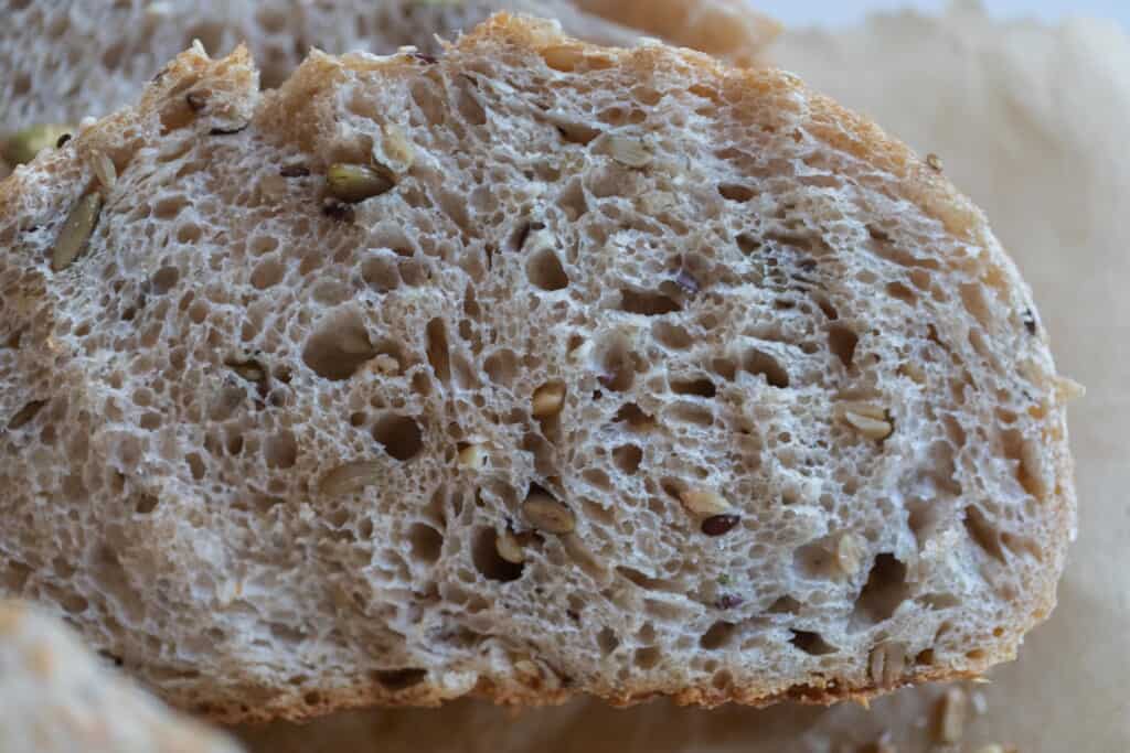 A cut slice of seeded sourdough bread close up