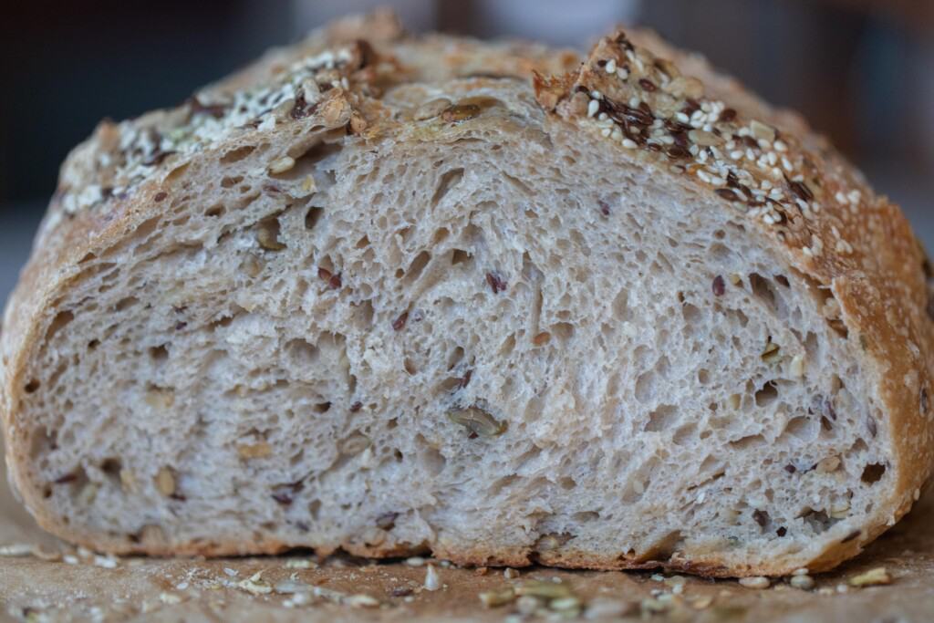 A loaf of seeded sourdough bread sliced into