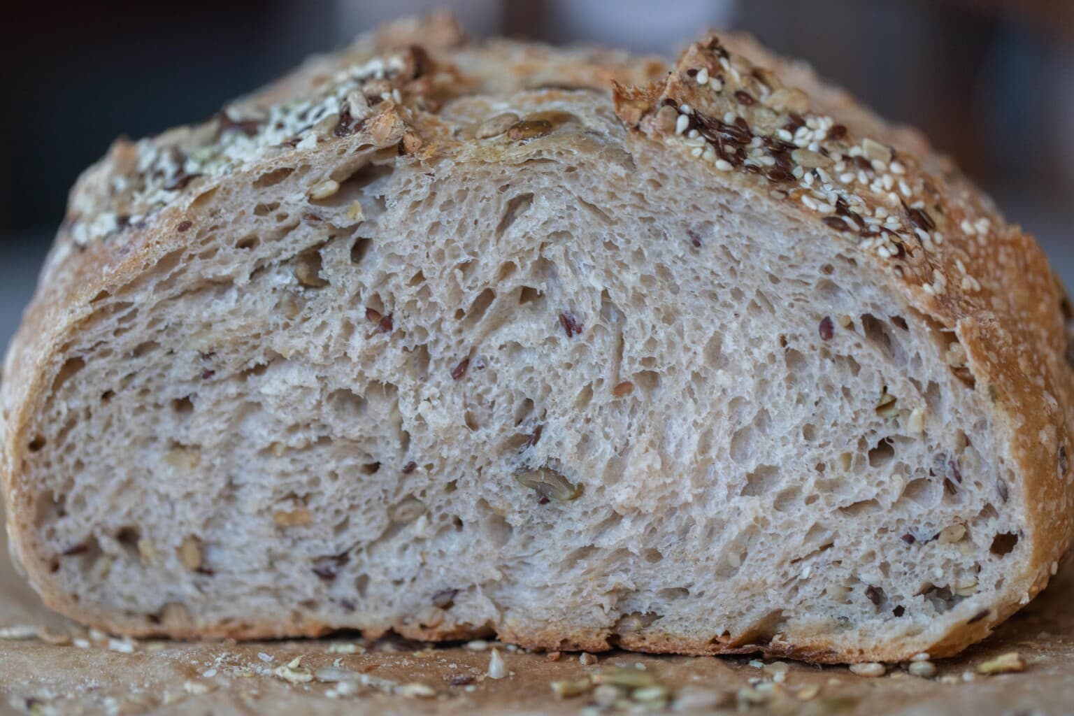 A loaf of seeded sourdough bread sliced into