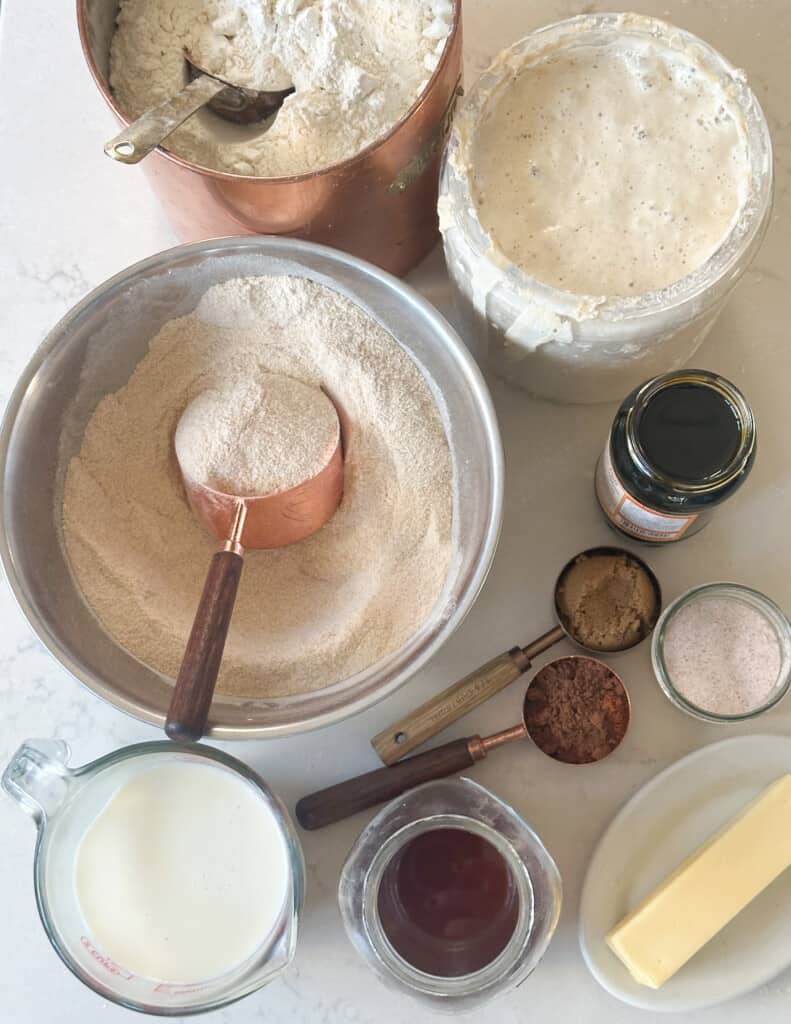 aerial photo of ingredients in various sized bowls for sourdough brown bread