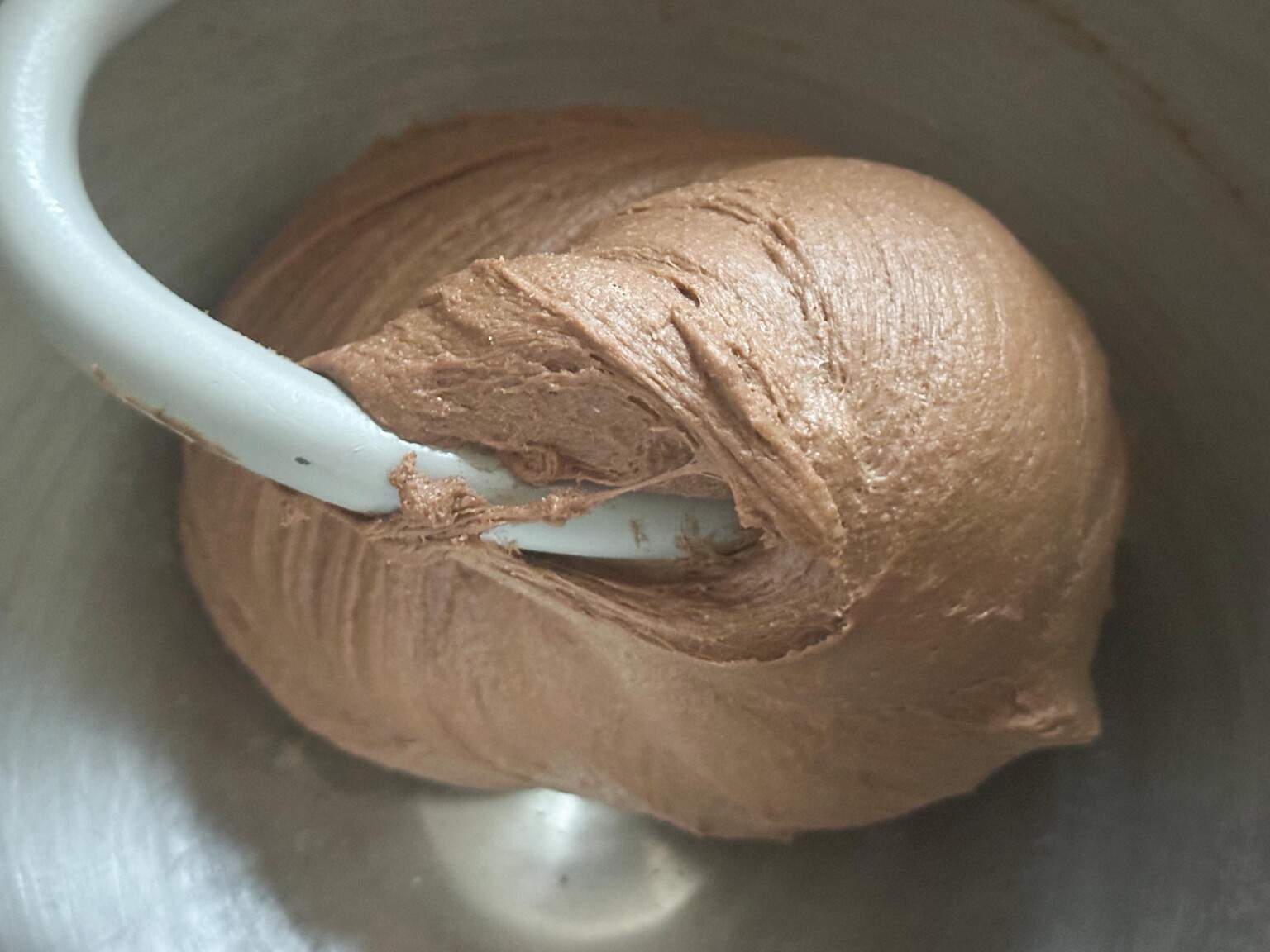 sourdough pumpernickel bread dough in a stand mixer bowl with a dough hook