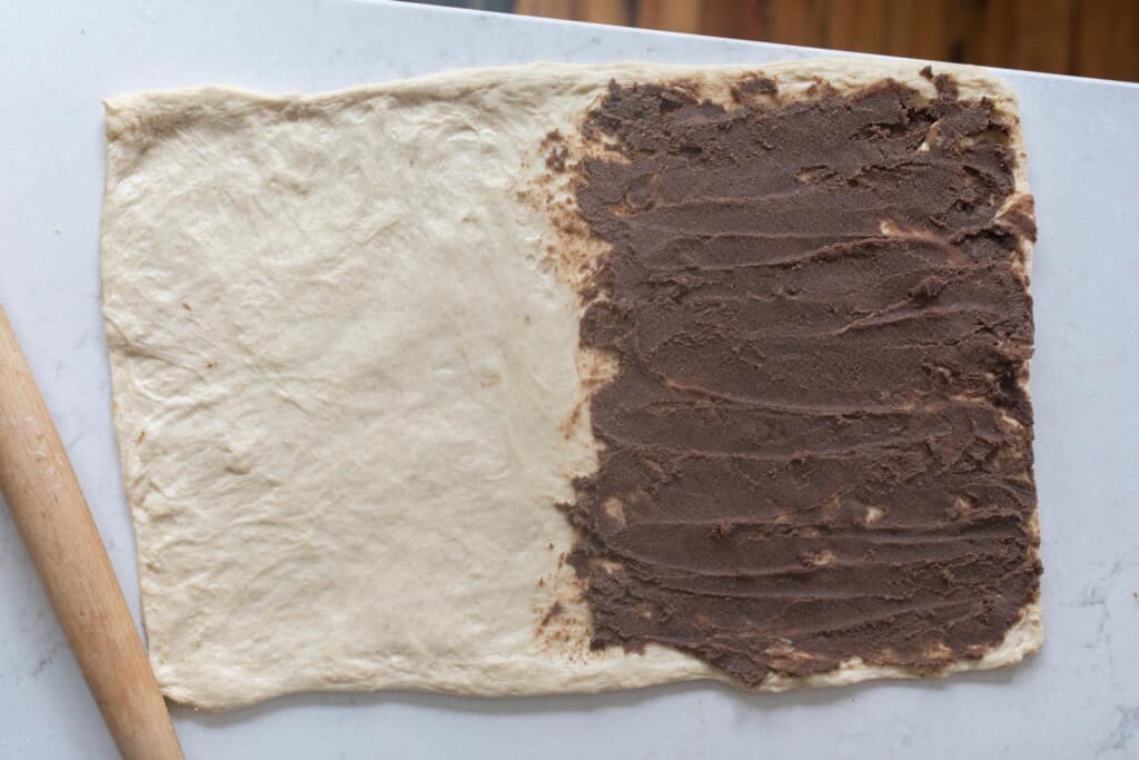 dough rolled out into a rectangle. Cinnamon filling spread on half of the rectangle