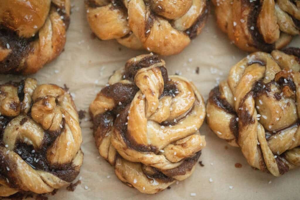 six sourdough Swedish cinnamon buns on parchment paper