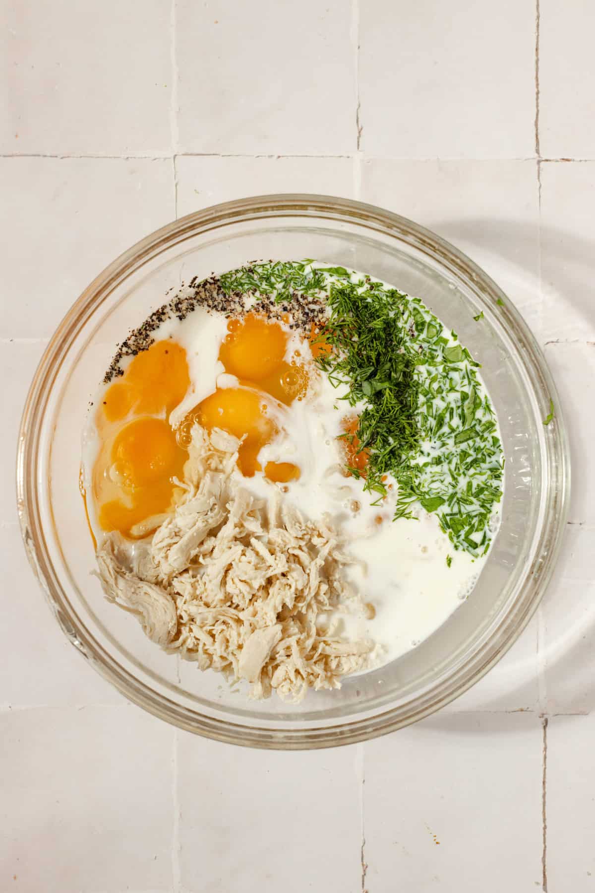 overhead view of a large bowl with frittata ingredients inside ready to be mixed