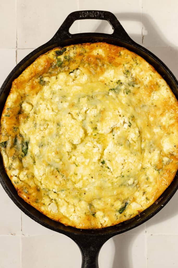 Overhead view of a chicken frittata in a cast iron skillet
