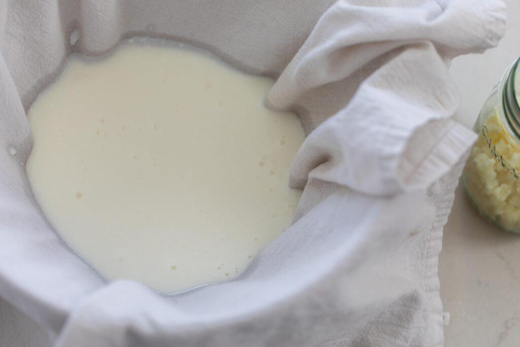 draining the whey out of milk kefir with a flour sack towel to make kefir cheese. 