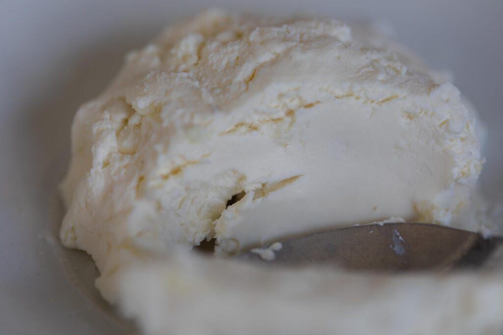 a block of kefir cheese with a silver butter knife slicing it