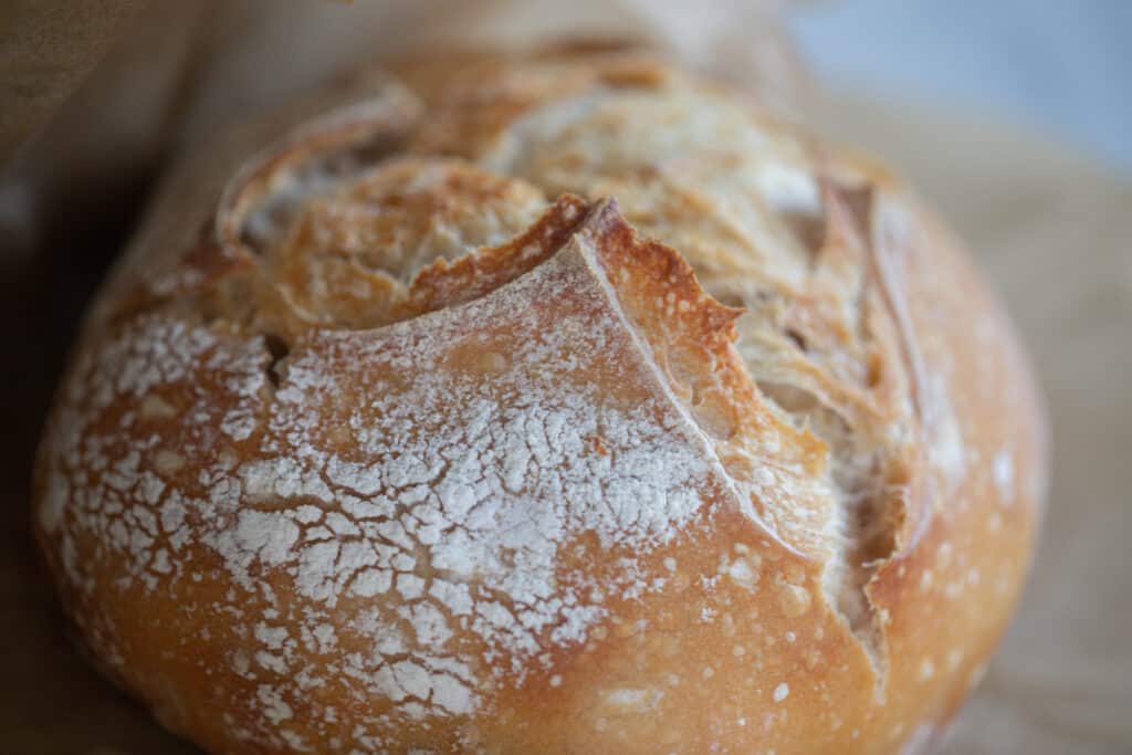 close up of a small batch sourdough bread loaf that has been baked until golden brown