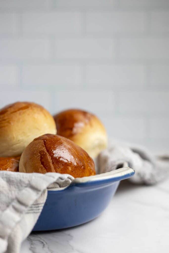 fluffy sourdough rolls made with discard in a blue dish lined with a towel