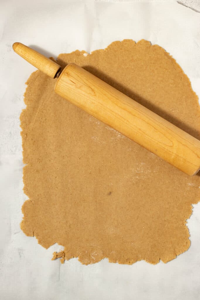 dough rolled out on a countertop with a rolling pin on top