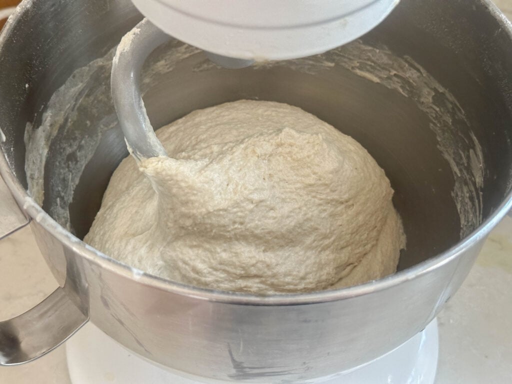 bread dough in a stand mixer bowl with a dough hook