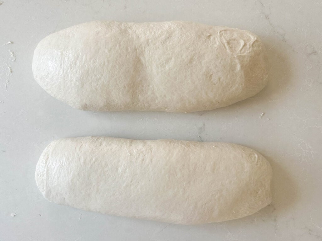 two loaves of bread dough shipped on a white countertop