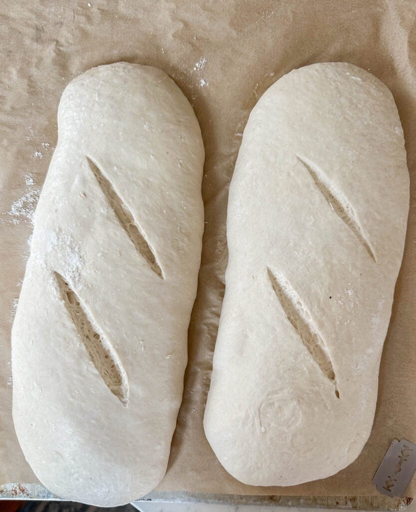 bread dough scored on the top. The dough is on parchment paper