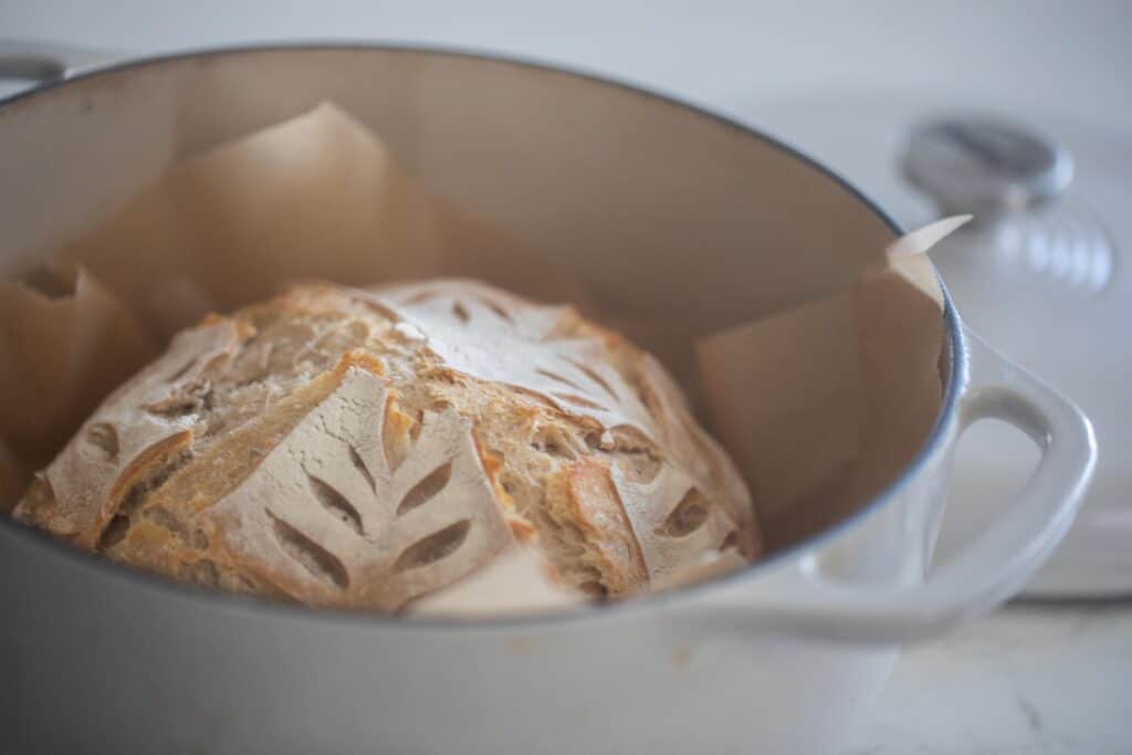 sourdough loaf in a white dutch oven 