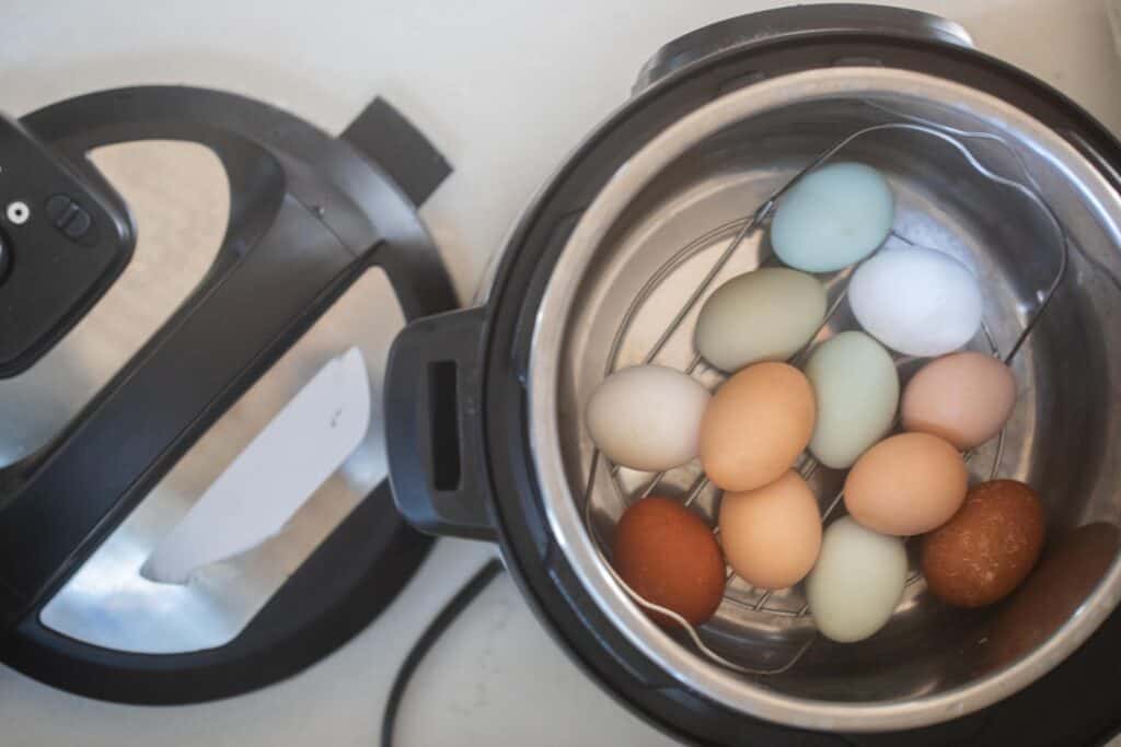 overhead photo of colorful farm fresh eggs in an Instant Pot with a trivet at the bottom.