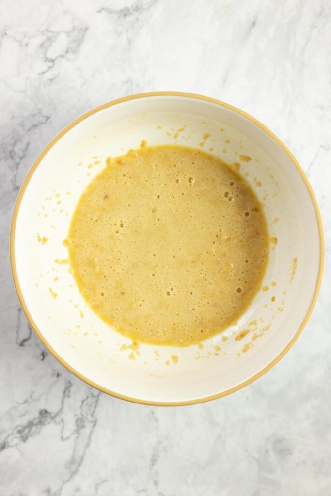 eggs, milk and breadcrumbs in a bowl on a marble countertop