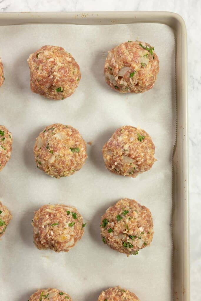 meatballs on a parchment lined baking sheet