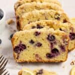 A loaf of sourdough blueberry bread cut into slices and leaning on each other