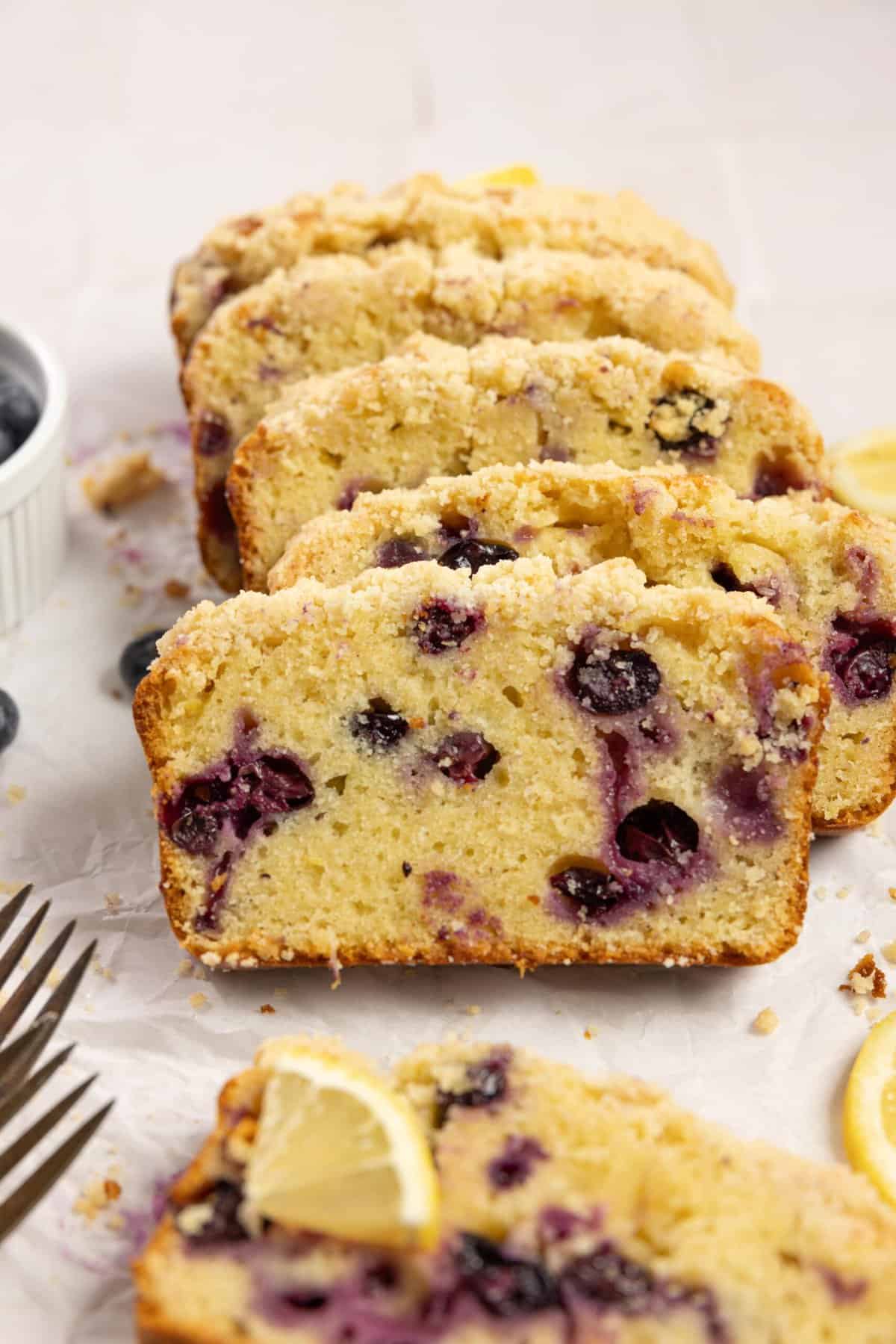 A loaf of sourdough blueberry bread cut into slices and leaning on each other