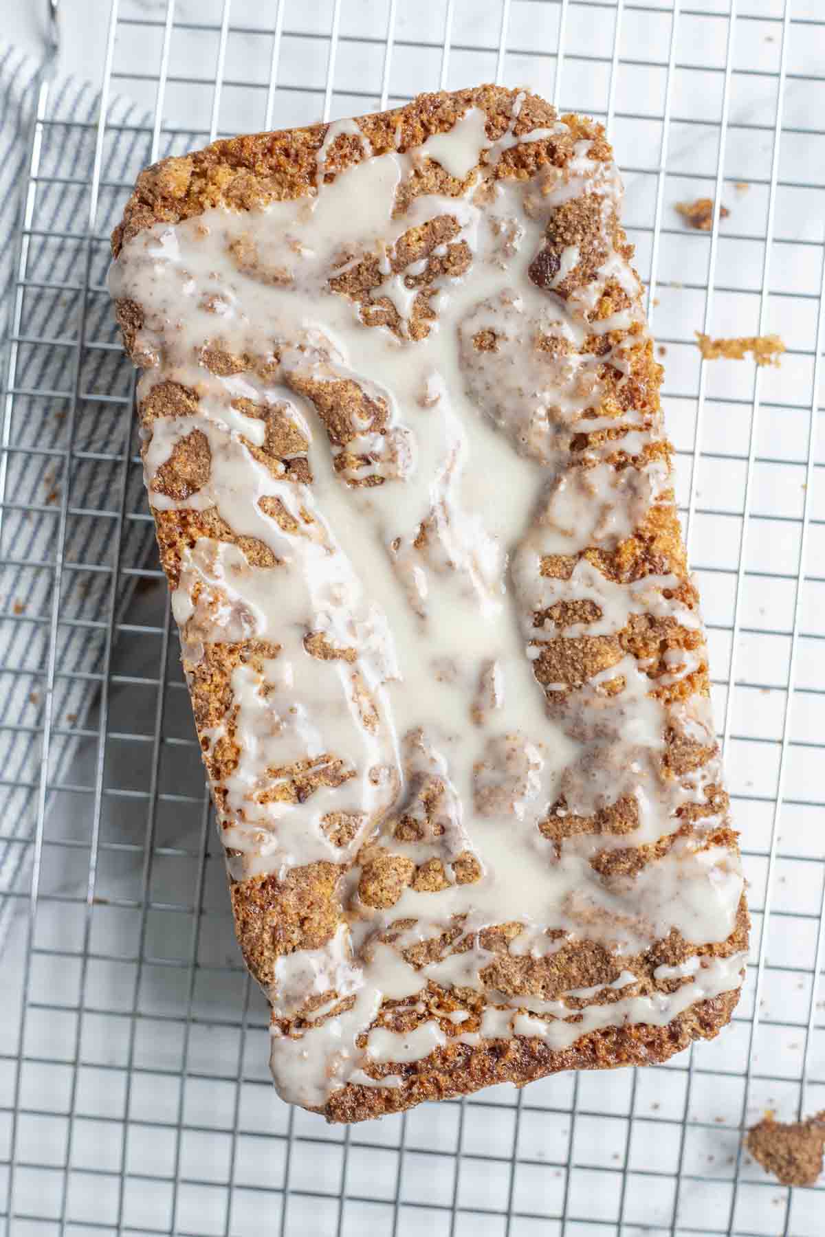 overhead photo of sourdough cinnamon quick bread topped with icing on a cooling rack