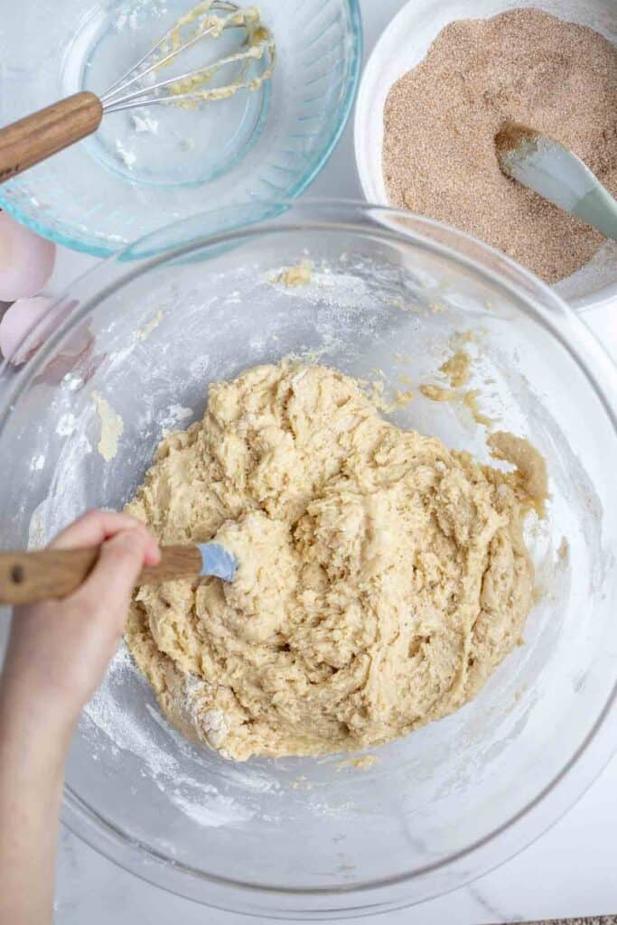 bread batter in a glass bowl surrounded by more bowls
