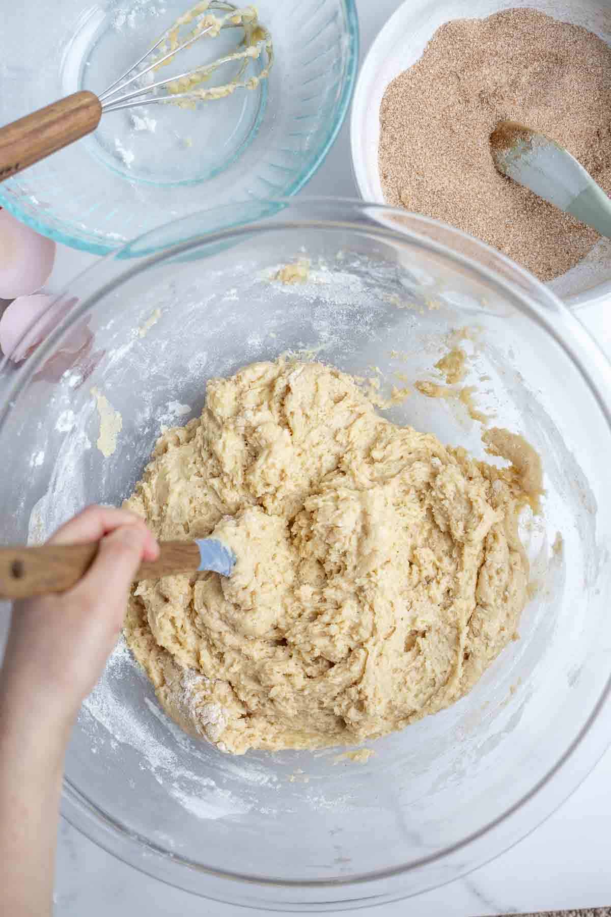 bread batter in a glass bowl surrounded by more bowls