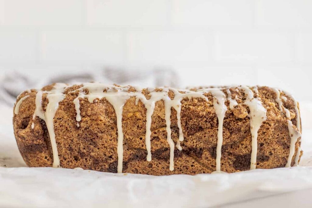 side view of a loaf of sourdough cinnamon bread drizzled with icing 