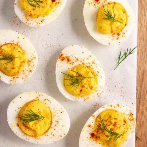 deviled eggs on a parchment paper on a wood countertop