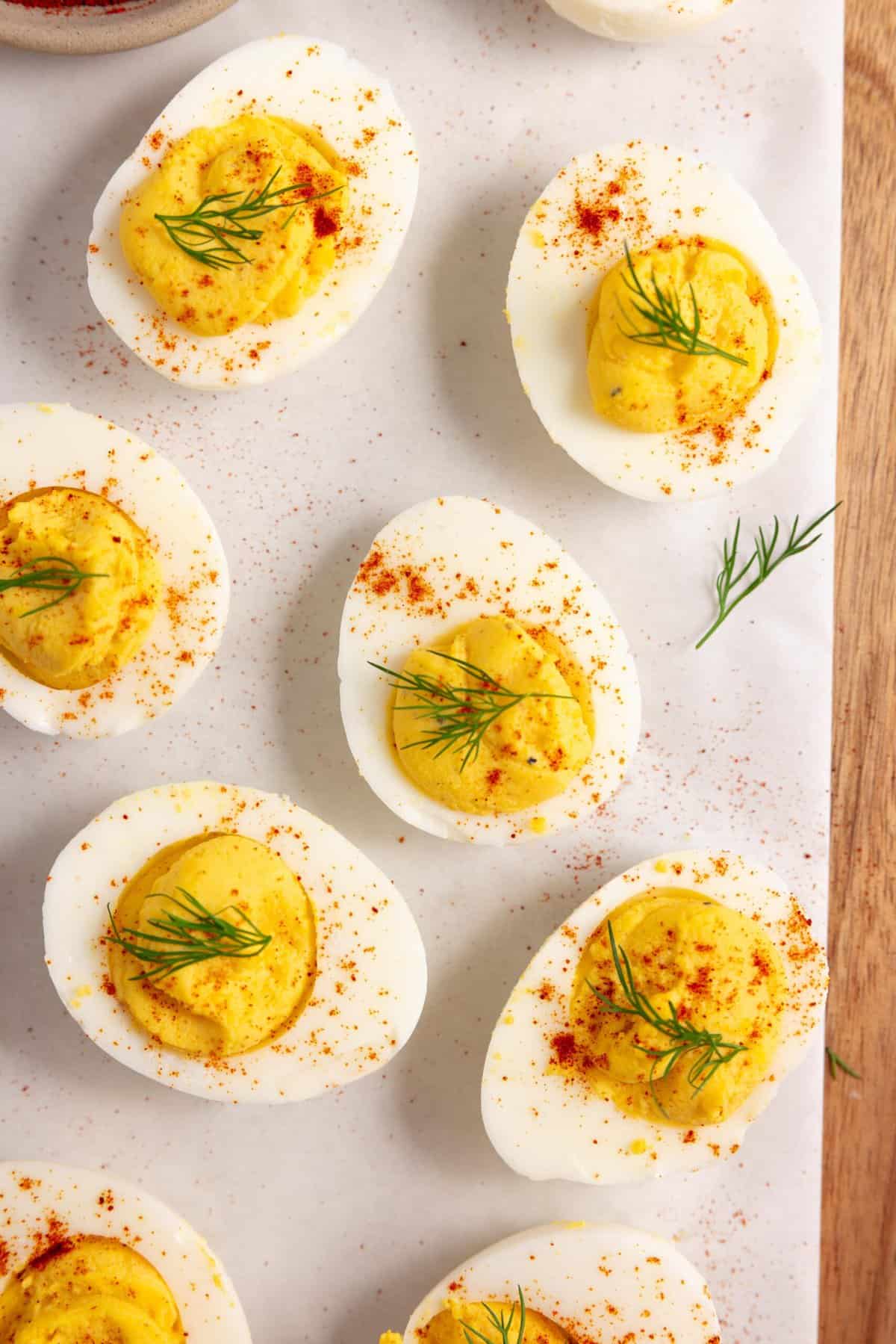 deviled eggs on a parchment paper on a wood countertop