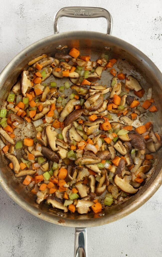 carrots, onions, celery, and mushrooms in a stainless pan