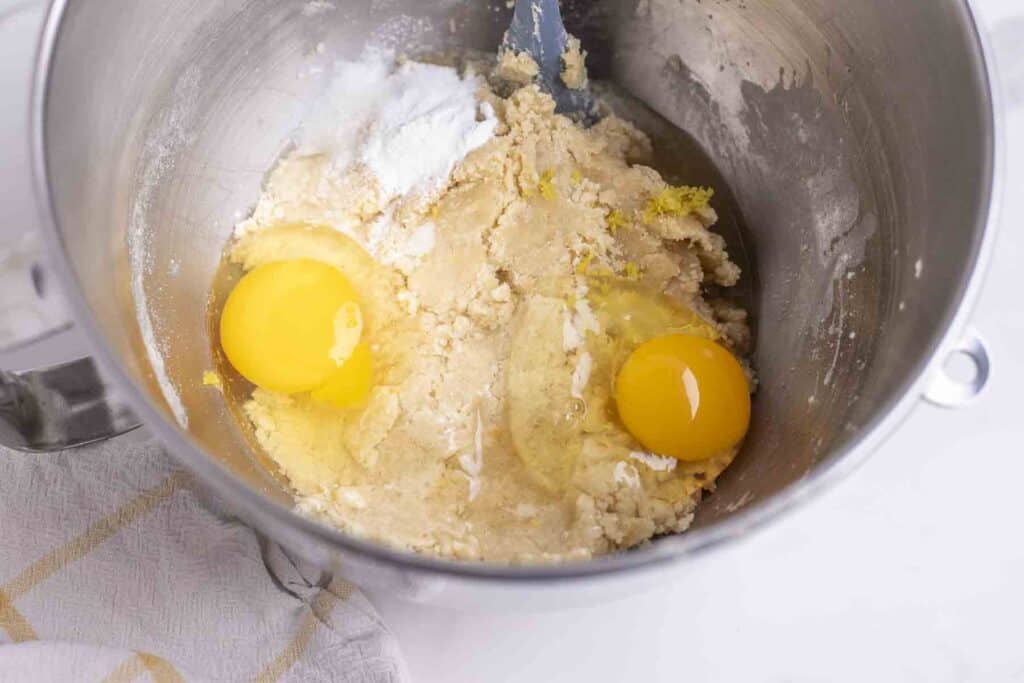 eggs added to fermented dough in a stainless bowl