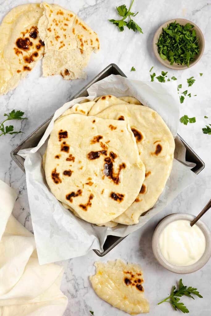 sourdough naan surrounded by toppings and dip