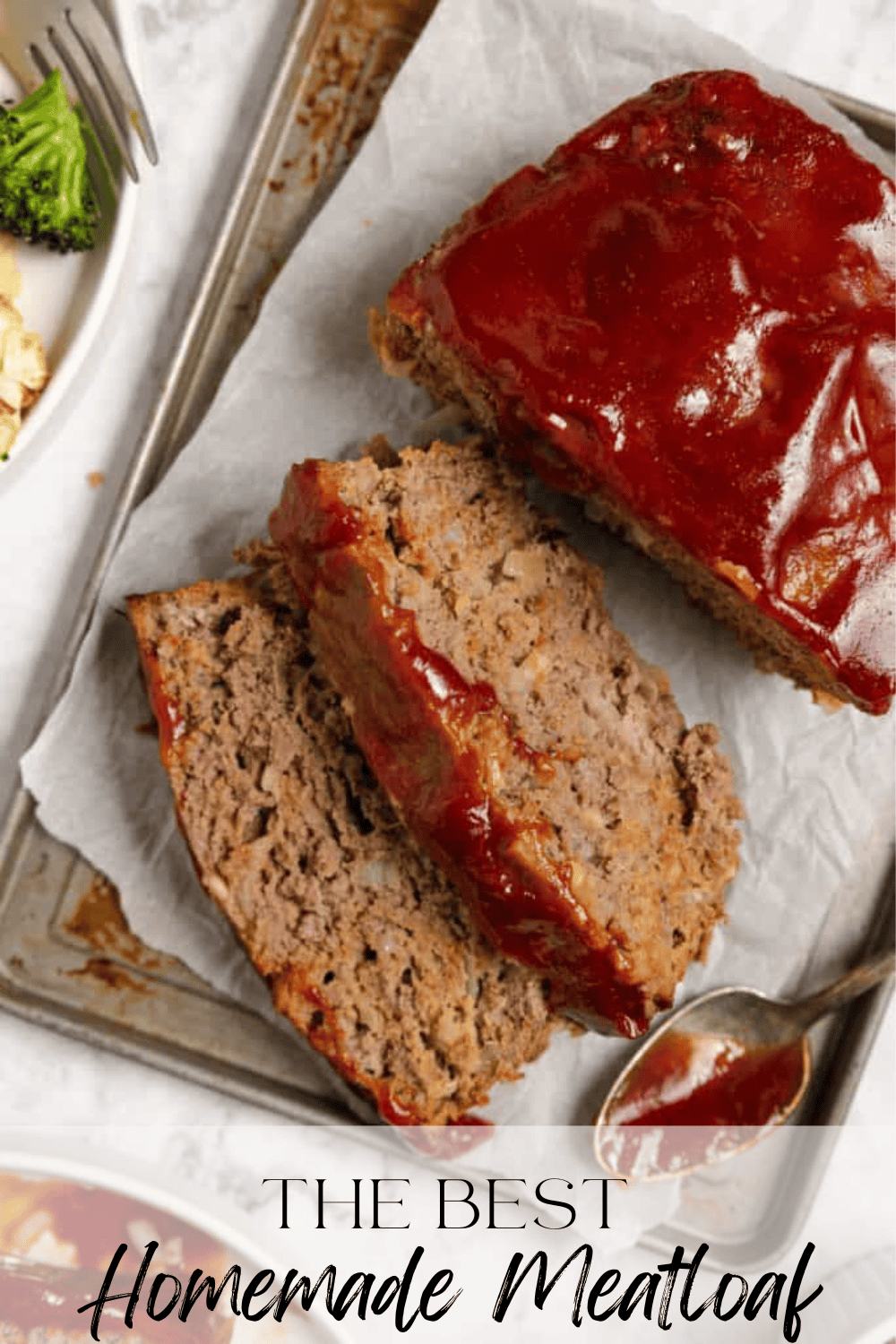 The ingredients for meatloaf spread out on a white countertop, including two eggs, ketchup, ground beef, onion, and spices.